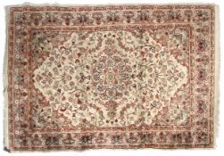 A cream ground rug with red decoration.