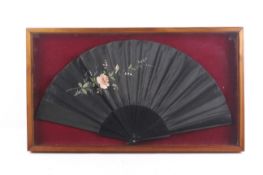 An Edwardian black folding fan.