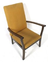A circa 1960s stained wood open armchair with yellow textured upholstery.