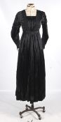 A Victorian style black silk satin dress and an early 20th century headpiece.