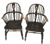 A pair of dark stained elm Windsor chairs. With pierced back splat, on turned supports.
