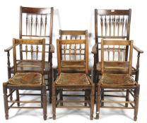A set of two elm carvers and six spindle back chairs. On turned supports, carvers H112cm.