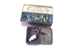 A vintage tin of lead animals and another of German glass marbles