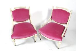 A pair of French style carved and white painted framed open armchairs.