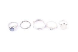 A group of five silver rings including opal and quartz