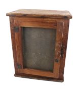 A mixed wood meat safe cabinet with wire mesh windows.