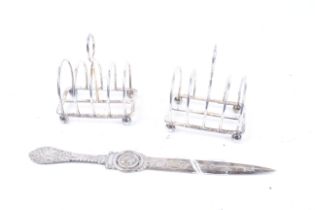 A pair of small silver toast racks with four arched-wire divisions and bun feet, Sheffield 1917,
