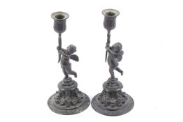 A pair of 19th century bronze cherub candlesticks.