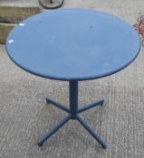 A circular metal tilt top cafe table.