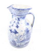 A very large blue and white 'Delftware' jug. With a scene of two gentlemen walking in a garden.