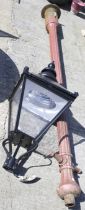 A vintage cast iron lamp post with a modern light fitting.