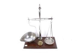 A vintage set of balance scales and five weights. Mounted on a wood stand. Total H42cm.