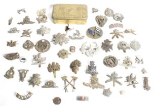 A large quantity of military cap badges and a Princess Mary gift box.