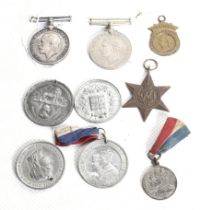 A group of WWI and WWII medals and other tokens.