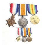 A set of three WWI medals and miniatures, a ship insignia and a cap badge.