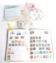 A collection of stamps in a vintage Royal Mail album and various loose stamps.