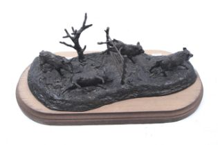 A contemporary bronze effect sculpture group of 'wild boar running'. Mounted on a wooden plinth.