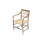 A 19th century faux bamboo chair. Painted and with carved decoration and a rush work seat.