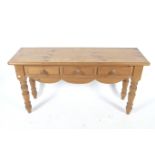 A vintage pine sideboard. Three drawers, raised on turned supports,