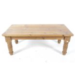 A contemporary pine coffee table. With rounded corners and four turned supports.