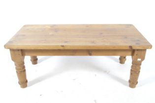 A contemporary pine coffee table. With rounded corners and four turned supports.