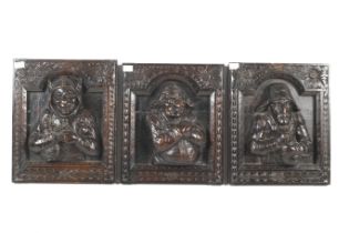 Three carved wooden figural panels.