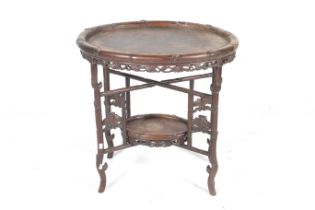 An early 20th century oriental carved hardwood folding table.