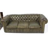 A three seater green leather Chesterfield sofa. Button back, with scroll arms. Some wear.
