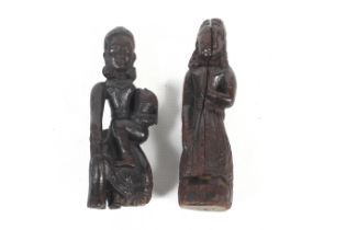 A pair of carved wooden figurines. Modelled as deities, one of a woman holding a child, H18.