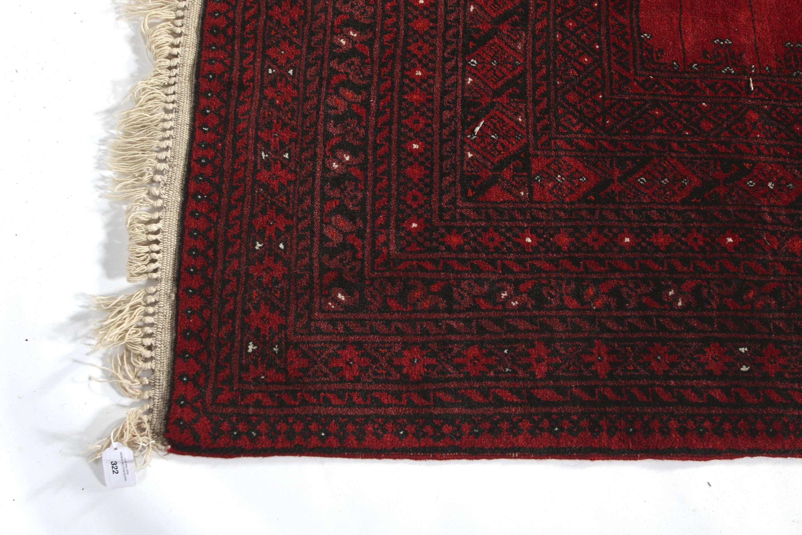 A large 20th century Bokhara Persian style red wool carpet rug. - Image 2 of 3