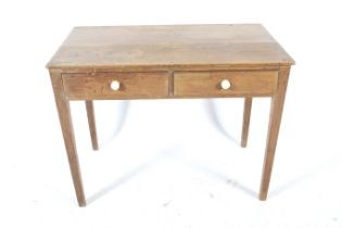 A vintage pine table. Having two drawers with ceramic handles, on tapered supports,