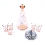 A vintage pink glass decanter and five glasses and a paperweight.