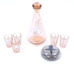 A vintage pink glass decanter and five glasses and a paperweight.