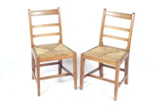 A pair of ladderback chairs. With drop in rush seats, raised on tapered supports.