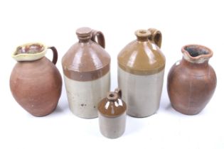 Three stoneware cider flagons and two terracotta jugs.