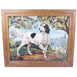 A framed needlepoint panel depicting a hunting dog.