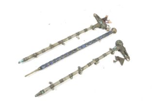 Three ethnic white metal covered walking sticks.