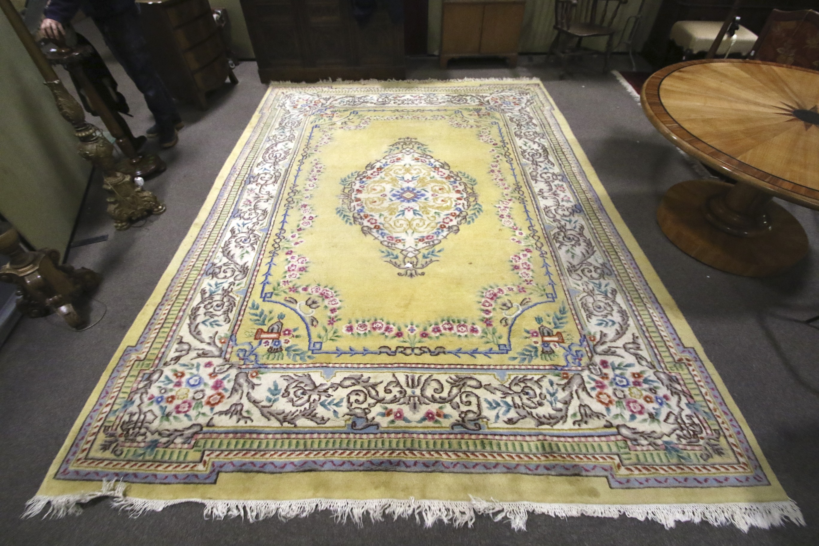 A large Chinese style yellow ground wool rug.