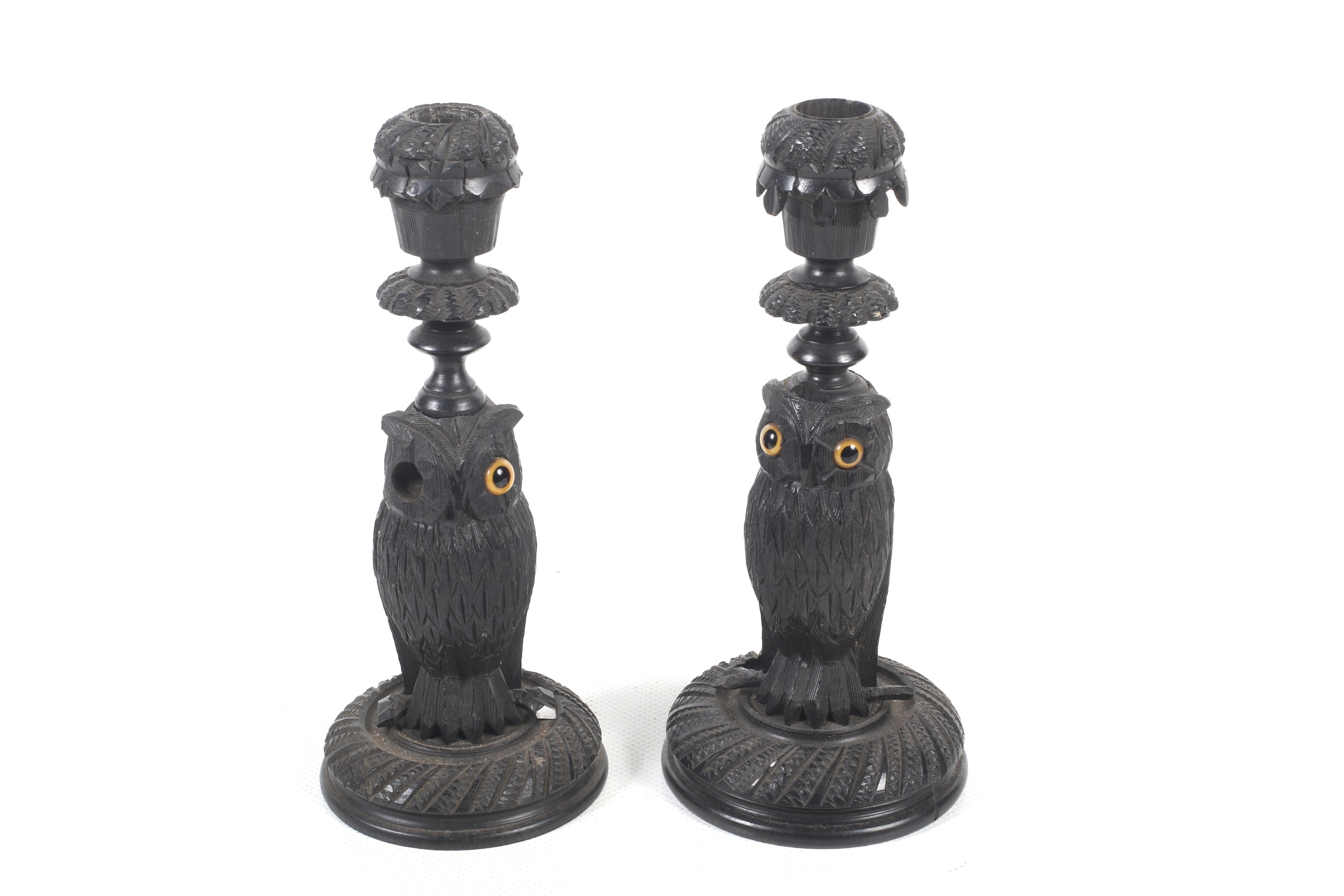 A pair of carved bog oak candlesticks.