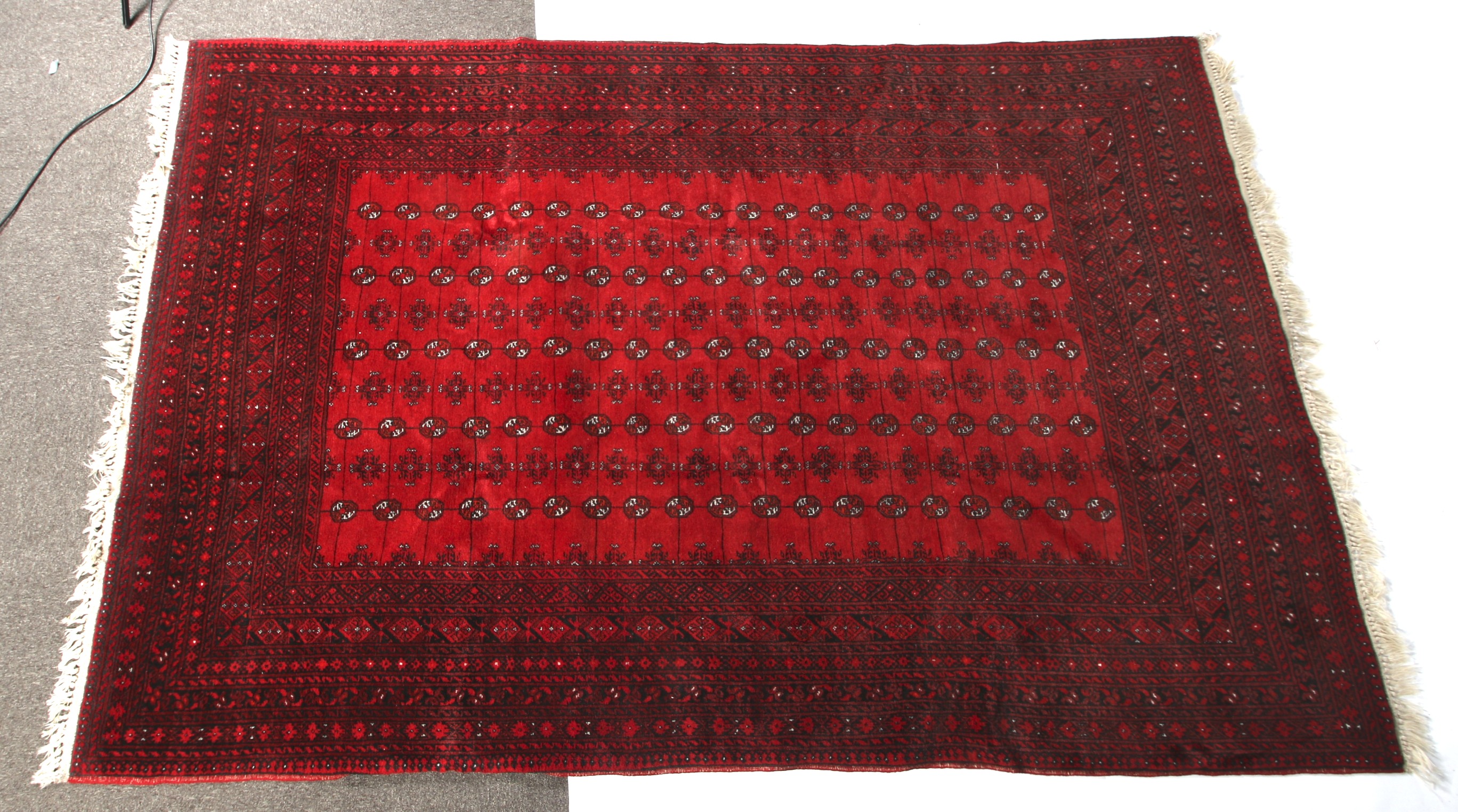 A large 20th century Bokhara Persian style red wool carpet rug.
