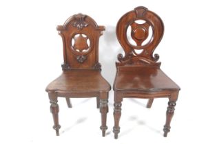 Two Victorian carved wooden shield back mahogany hall chairs.