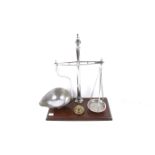 A vintage set of balance scales and five weights. Mounted on a wood stand. Total H42cm.