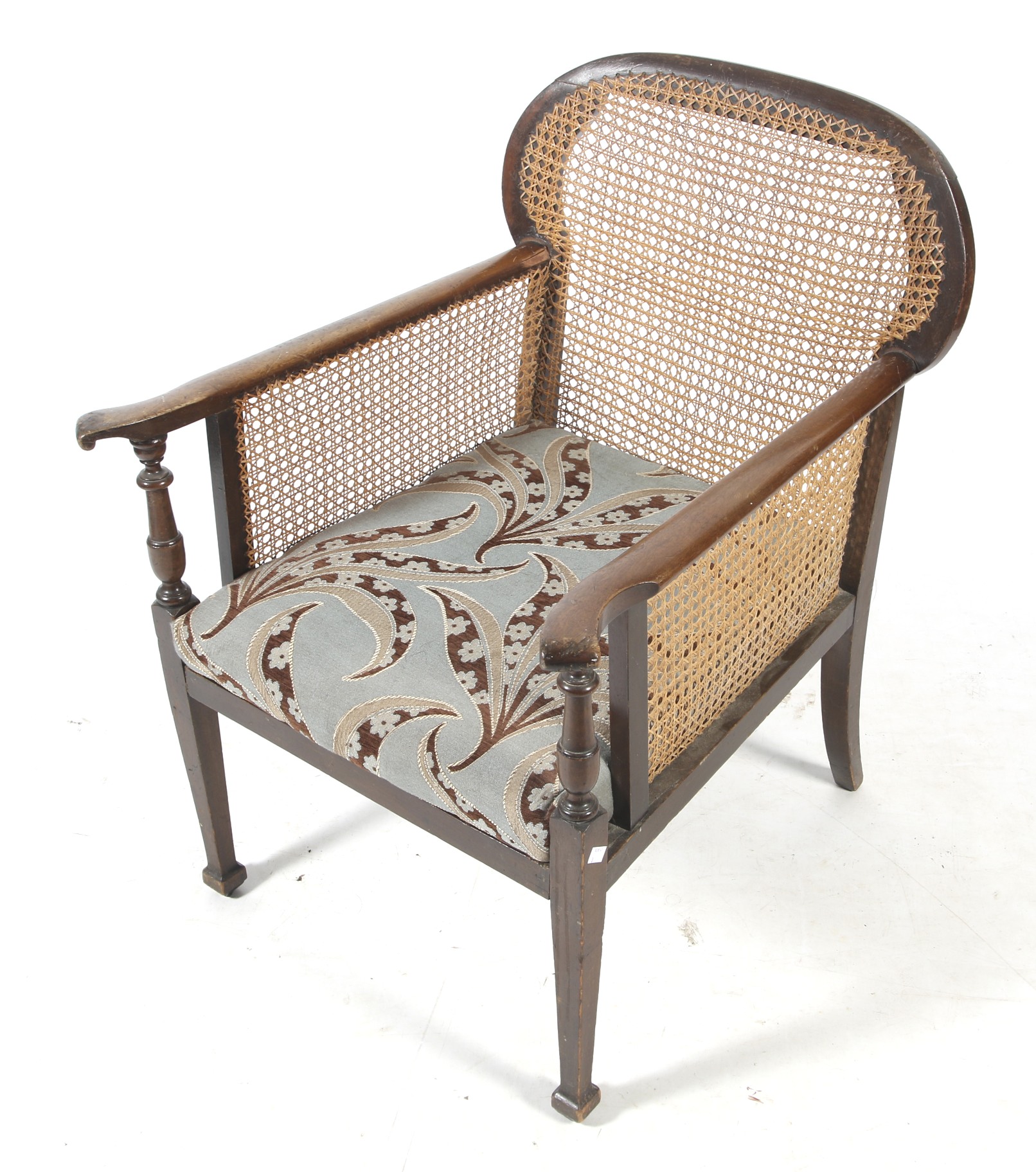 An Edwardian mahogany and cane bergere armchair.