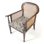 An Edwardian mahogany and cane bergere armchair.
