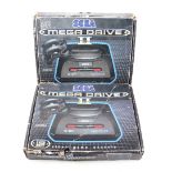 Two Sega Mega Drive 2 video game consoles.