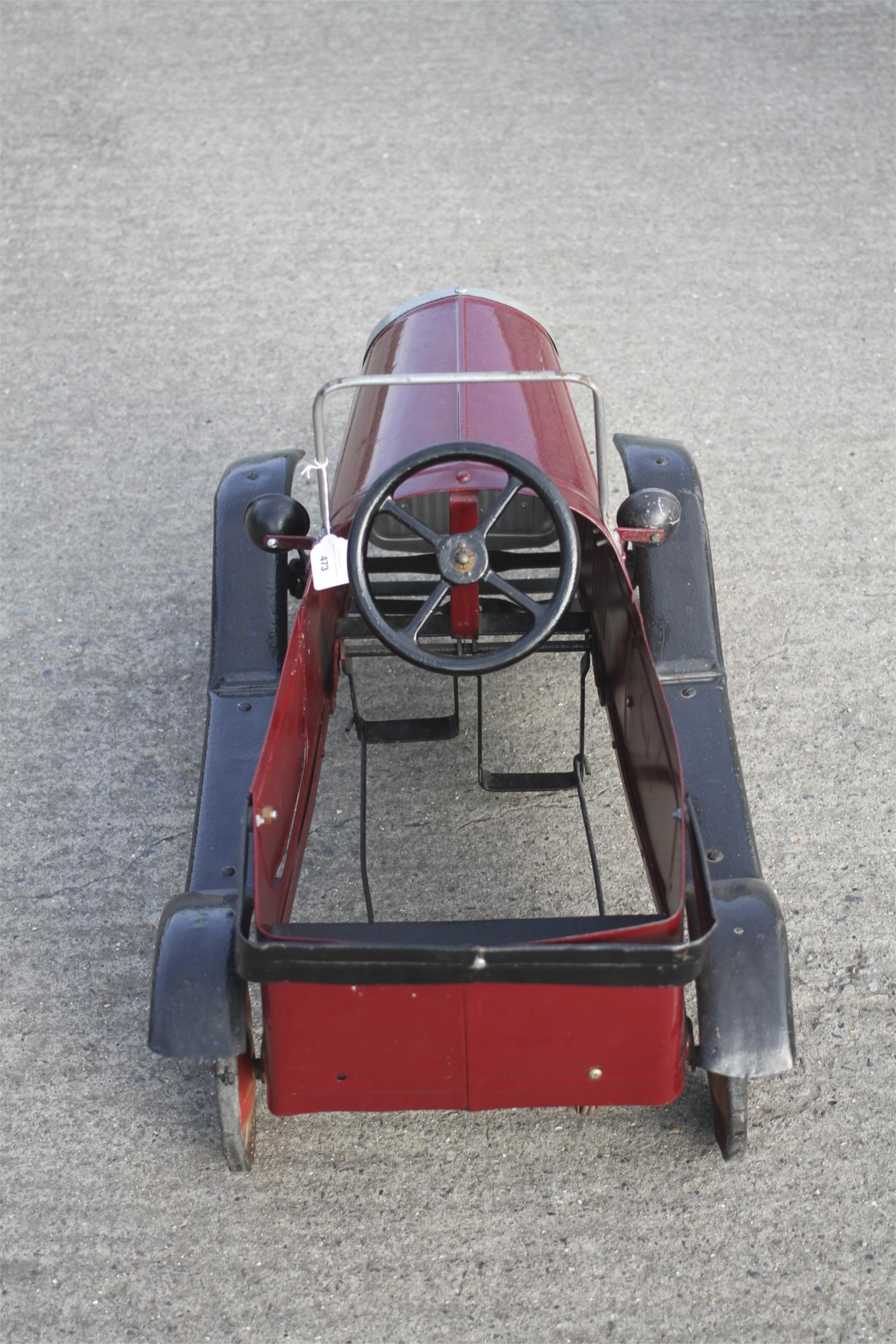 A circa 1930s tin plate pedal car. Red body with black trim and red wheels, H49cm x L77cm. - Image 3 of 3