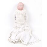 A German Bisque shoulder doll. Signed G konch, wearing a white dress, H46cm.