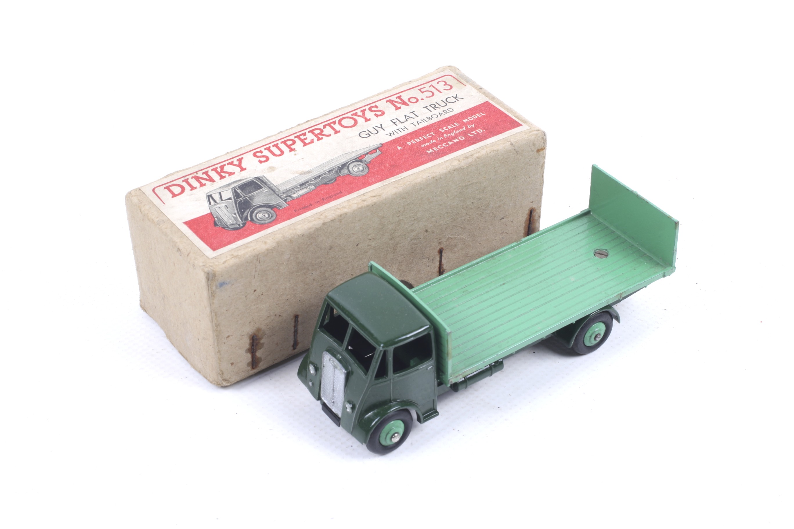 A Dinky diecast Guy Flatbed Truck. No. 513, dark green body with light green bed, in original box.