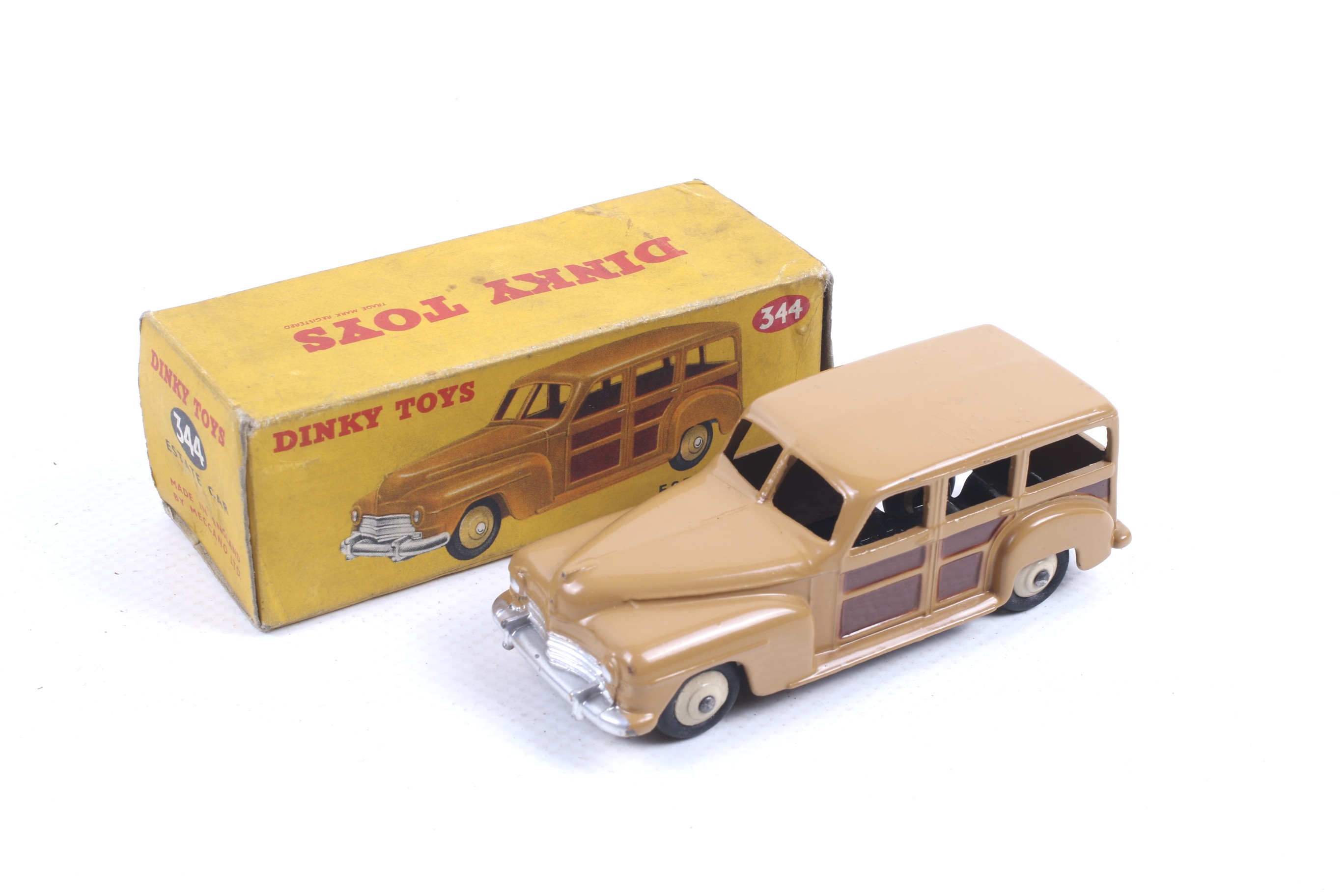 A Dinky diecast Estate Car. No. 344, with a tan and brown body with white wheels, in original box.