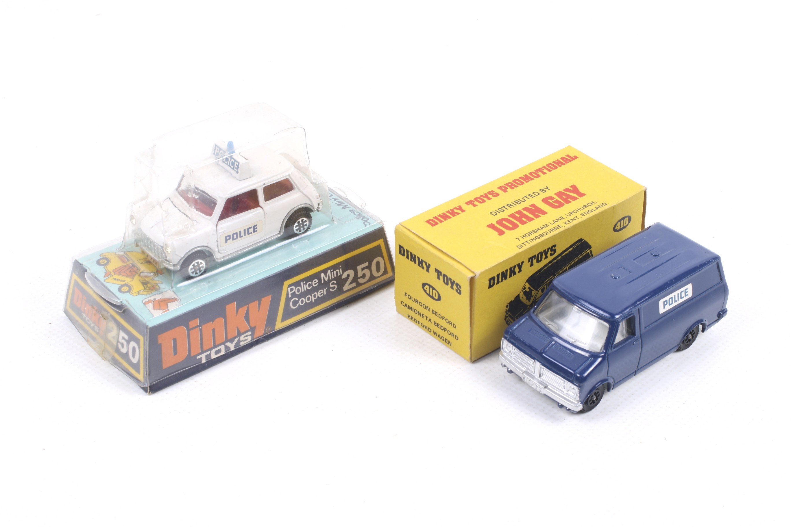Two Dinky diecast police cars. Comprising one John Gay promotional Bedford Van no.